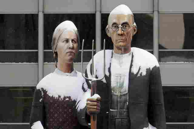 This is an image of a statue version of the painting 'American Gothic,' on display in a snowy Chicago in 2009.